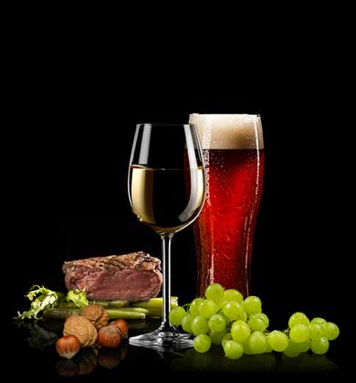 A glass of white wine, glass of dark beer with foam, and a sliced piece of grilled beef.