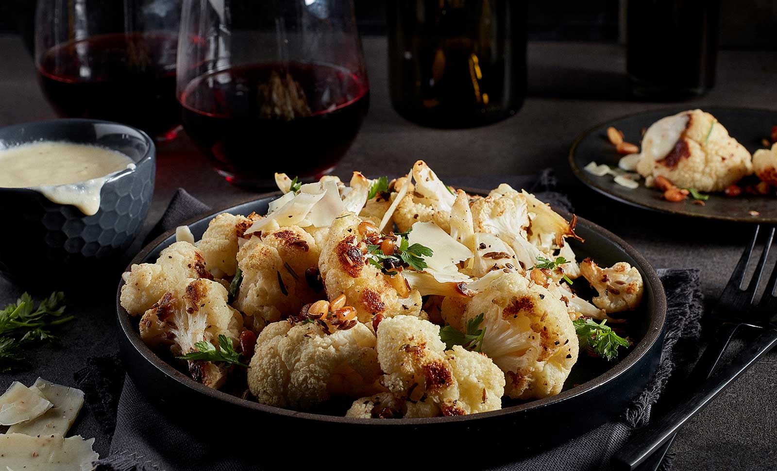 A plate of cauliflower bites garnished with herbs.