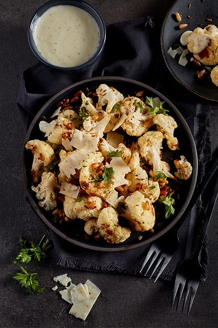 A plate of cauliflower bites garnished with herbs.
