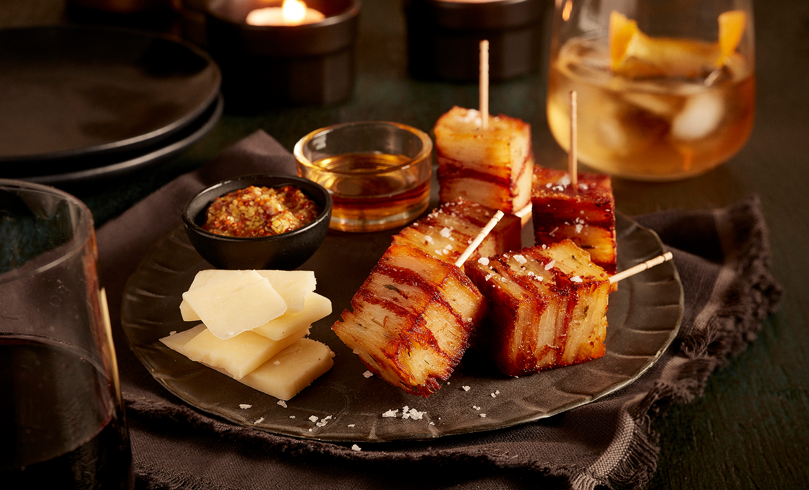 Four pieces of potato pave served with slices of naturally aged cheddar cheese and a small bowl of honey.